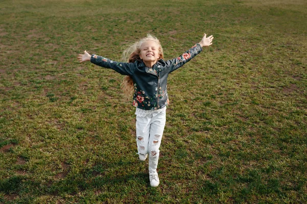 Mooie kleine kind meisje loopt op een groen gazon — Stockfoto