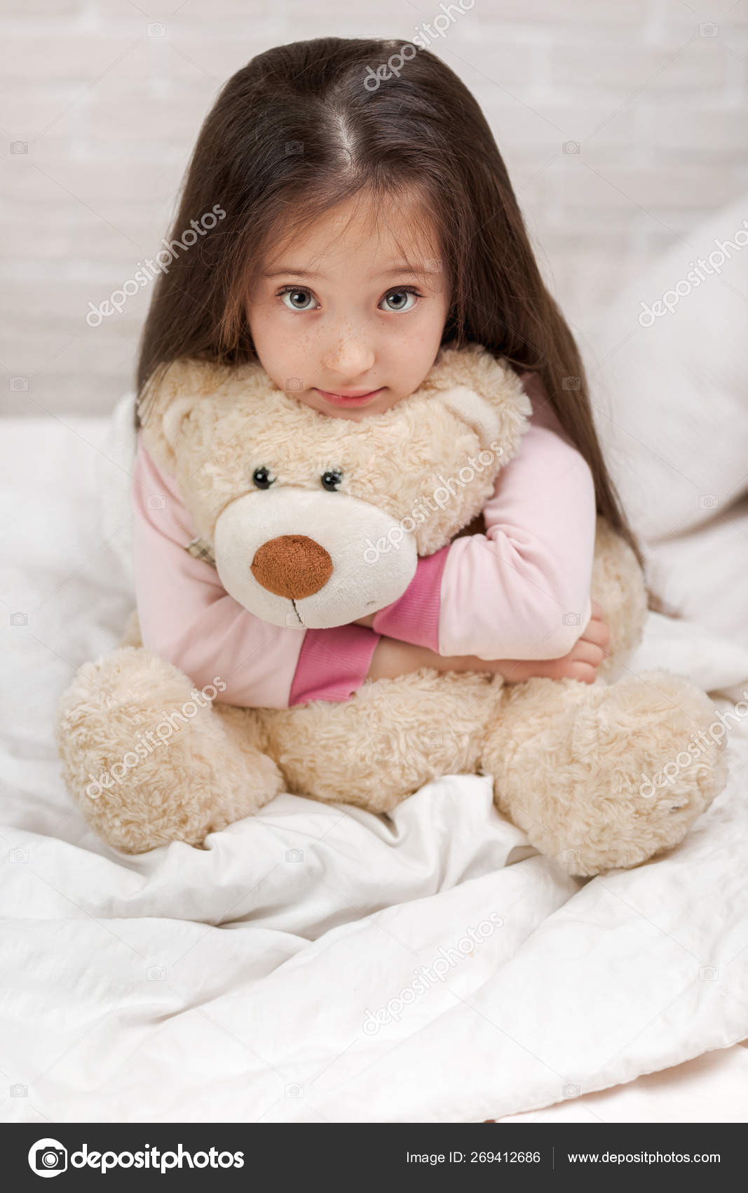 baby hugging teddy bear