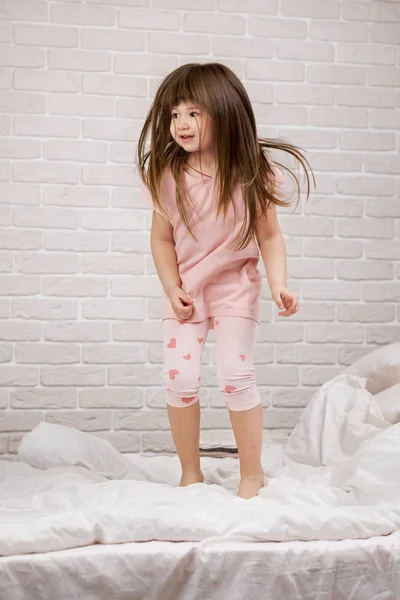 Mignon petit enfant fille tromper autour dans lit — Photo
