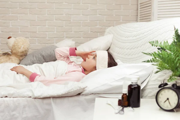 Enfermo frío niño niña se encuentra en la cama —  Fotos de Stock