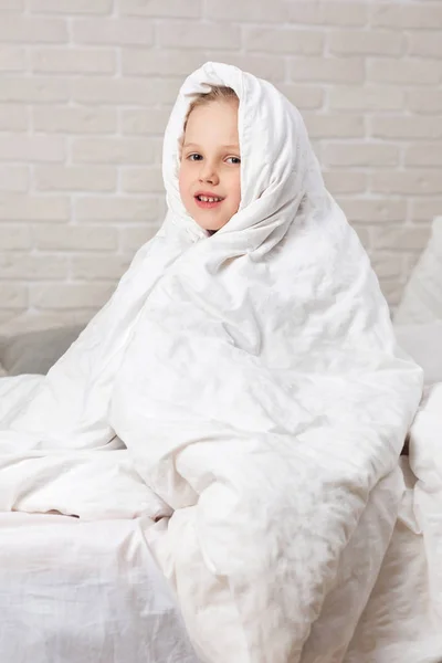 Child girl in blanket sitting on bed — Stock Photo, Image