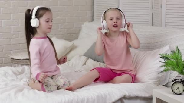 Маленькая девочка девочка слушает музыку в наушниках — стоковое видео