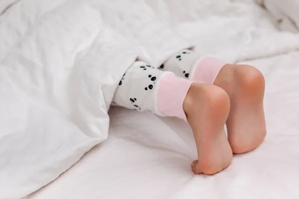 Par de criança descalço na cama — Fotografia de Stock