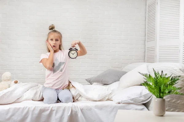 Menina em pijama com relógio — Fotografia de Stock