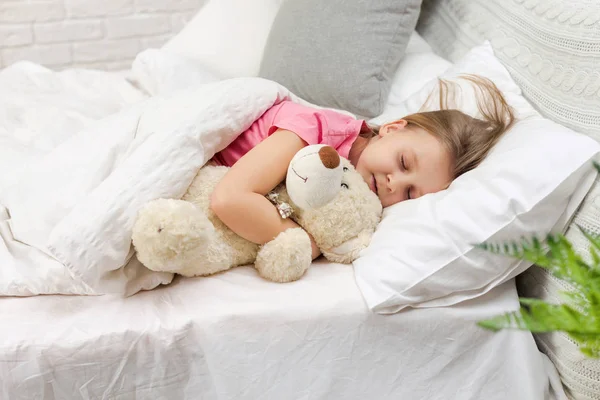 Linda niña durmiendo con oso de peluche —  Fotos de Stock