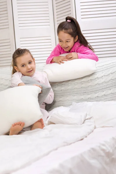Dwa szczęśliwe słodkie dzieci dziewczyny bawią się w sypialni. — Zdjęcie stockowe