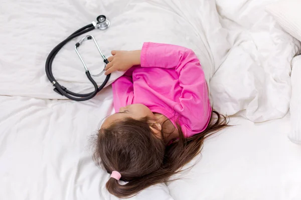 Sick little girl lying in bed — Stock Photo, Image