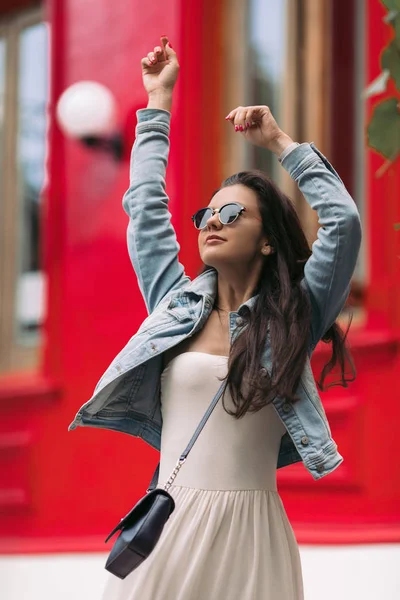 Mujer en gafas de sol pasea por las calles de la ciudad — Foto de Stock