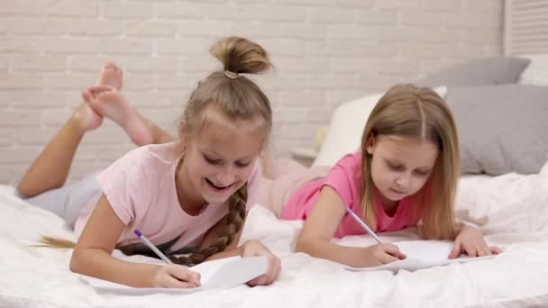 Bambini disegno immagini mentre sdraiati sul letto . — Video Stock