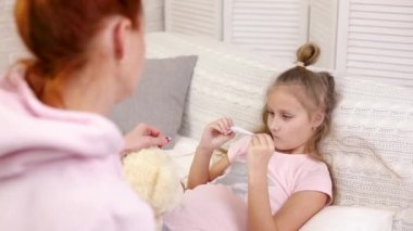 anne hasta bir çocuğun sıcaklığını ölçer