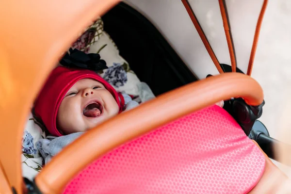 Pequeno bebê chorando em um carrinho — Fotografia de Stock