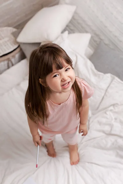 little child girl in pyjamas in bed.