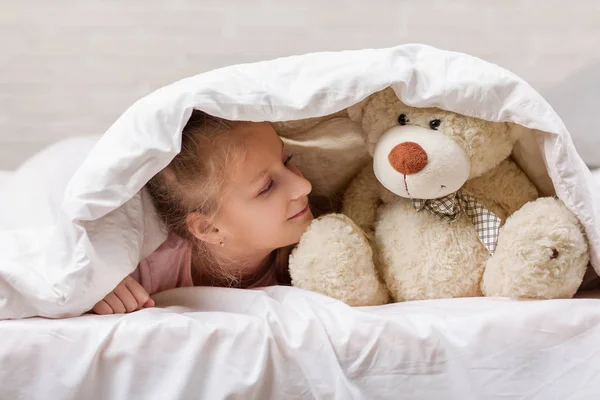 Маленька дівчинка грає з плюшевим ведмедем — стокове фото