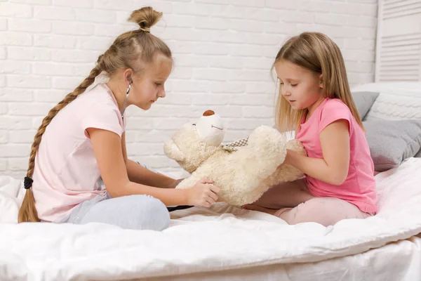 Zwei süße Kinder Mädchen spielen Arzt mit Teddybär — Stockfoto
