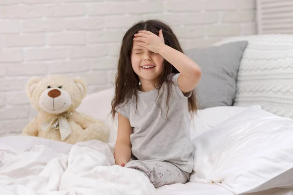 cute little child girl wakes up from sleep in bed