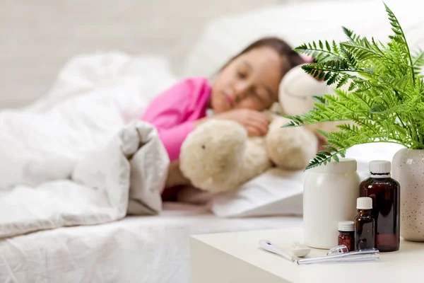 Niña enferma acostada en la cama con termómetro — Foto de Stock