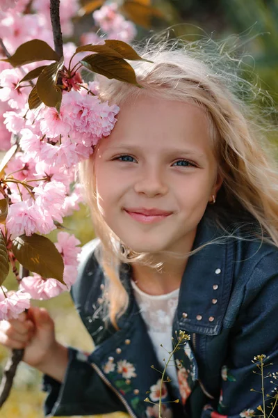 Hermosa niña con flores de sakura — Foto de Stock