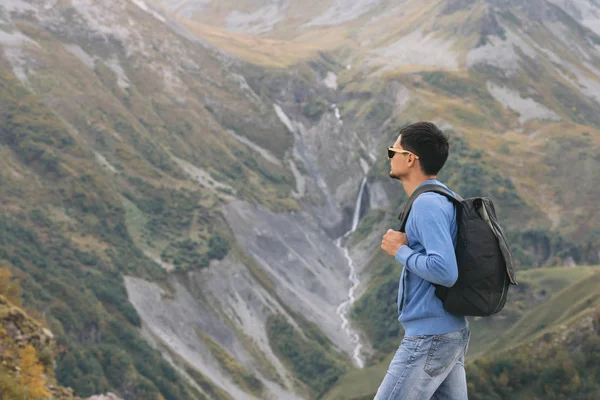Tourist man with a backpack against the Caucasus Mountains — Stock Photo, Image