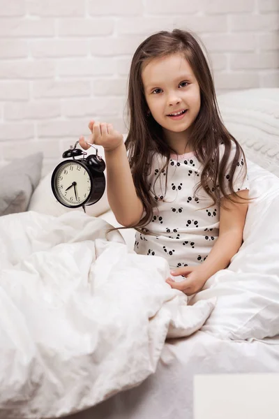 Niña en pijama con reloj — Foto de Stock