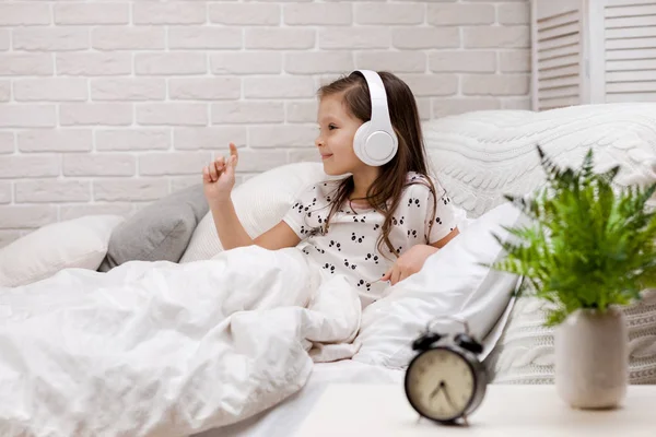 Mała dziewczynka słuchając muzyki ze słuchawkami — Zdjęcie stockowe