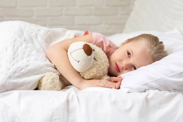 Sevimli küçük çocuk kız oyuncak ayı ile uyku — Stok fotoğraf