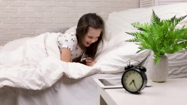 Linda niña despierta de dormir en la cama — Vídeos de Stock