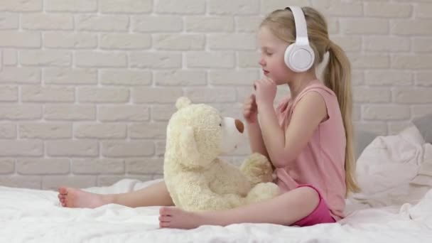 Lilla barnflicka lyssnar på musik med hörlurar — Stockvideo