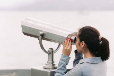 turist sikke işletilen dürbün ile bakıyor