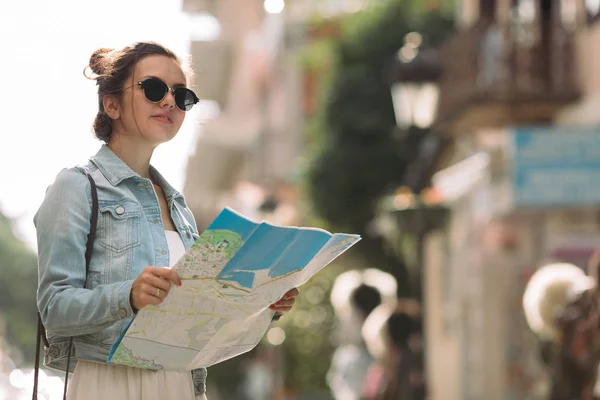 Туристична жінка дивиться на карту на вулиці — стокове фото