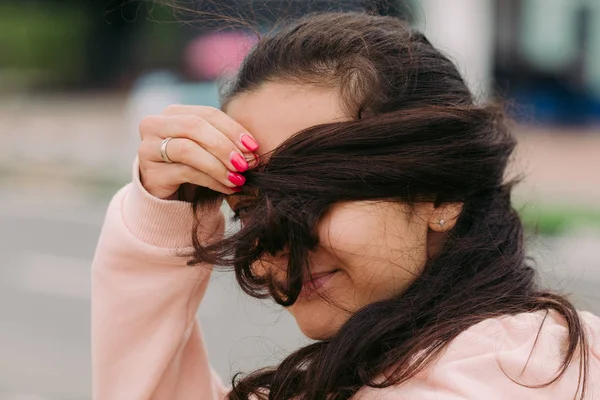 Dívka se vztahuje na její tvář s vlasy — Stock fotografie