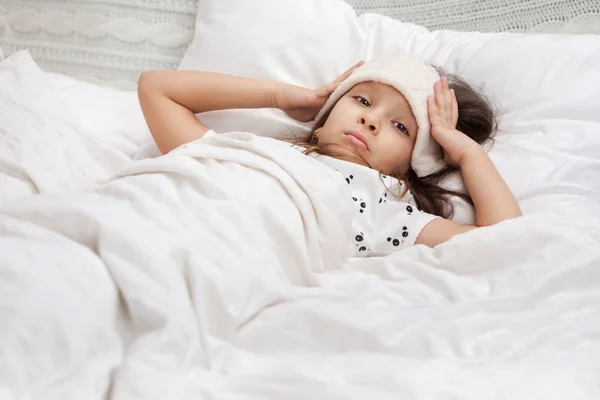 Malade froid petit enfant fille se trouve dans le lit — Photo