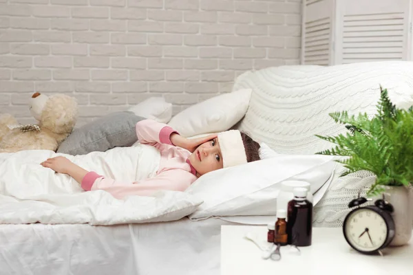 Enfermo frío niño niña se encuentra en la cama —  Fotos de Stock