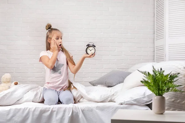 시계와 잠옷에 어린 소녀 — 스톡 사진