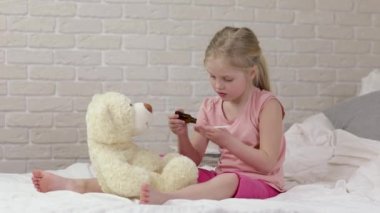 Sevimli çocuk kız oyuncak ayı ile doktor oynuyor