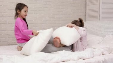yatak odasında oynayan iki sevimli çocuk kız.