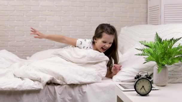 Linda menina criança acorda do sono na cama — Vídeo de Stock
