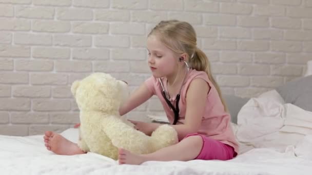 Schattig kind meisje spelen arts met Teddy Bear — Stockvideo