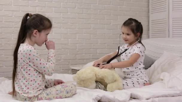 Dos lindo niños niñas jugando médico con osito de peluche — Vídeo de stock