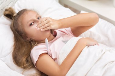 Termometre ile yatakta yatan hasta küçük kız