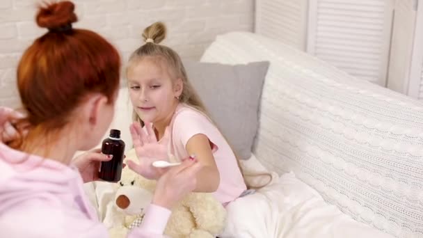 Мати наливає антипіратський сироп хворій маленькій дитині — стокове відео