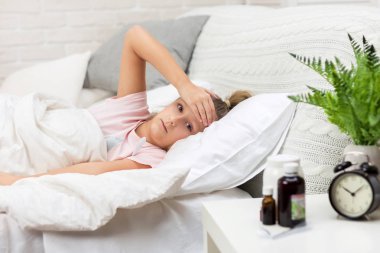 Termometre ile yatakta yatan hasta küçük kız