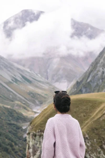 Junges Mädchen im Pullover blickt auf die kaukasischen Berge — Stockfoto