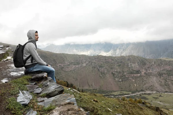 Tourist man with a backpack against the Caucasus Mountains — Stock Photo, Image