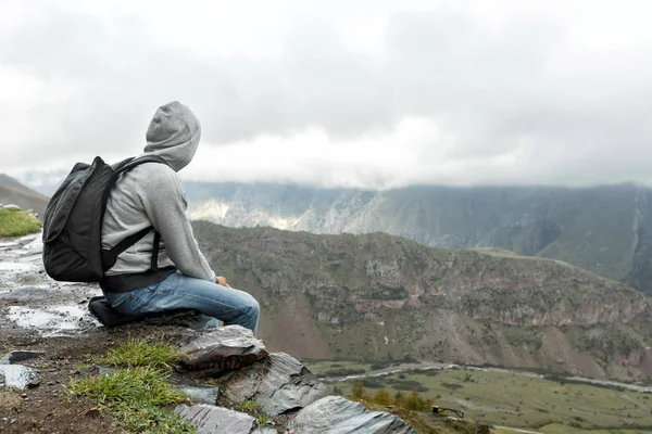 Tourist man with a backpack against the Caucasus Mountains — Stock Photo, Image