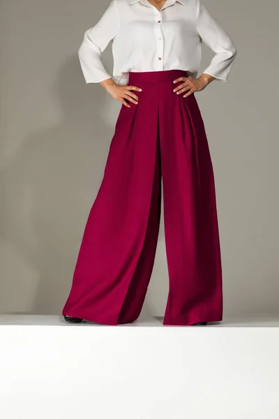 woman wearing high heeled shoes in burgundy trousers