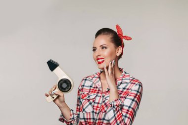 Saç kurutma makinesi ile mutlu genç esmer kadın.