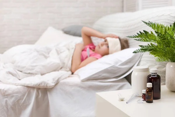 Krankes kleines Mädchen liegt mit Thermometer im Bett — Stockfoto