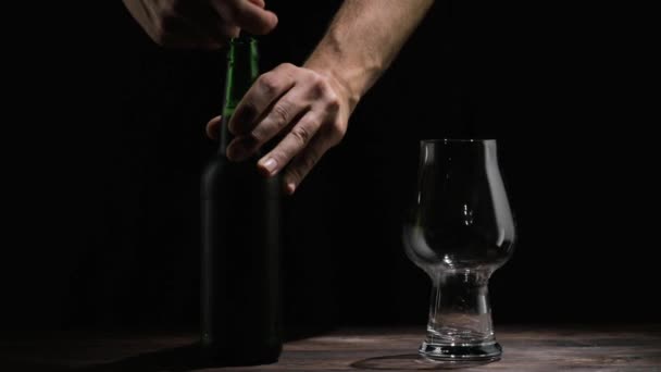 Mano masculina vierte cerveza en un vaso sobre la mesa — Vídeos de Stock