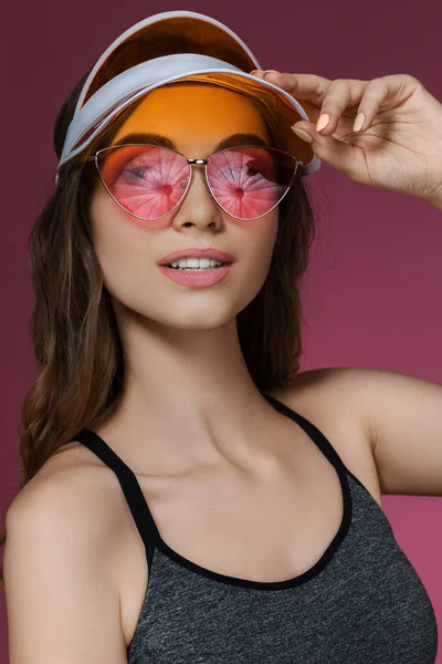 Portretul unei femei atractive în vizor de soare portocaliu și ochelari de soare — Fotografie, imagine de stoc