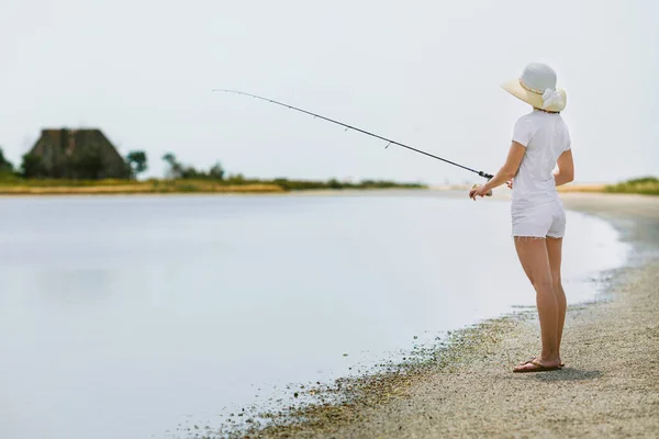 Mujer joven pescando en el mar — Foto de Stock